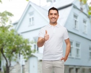 man showing thumbs up over house background